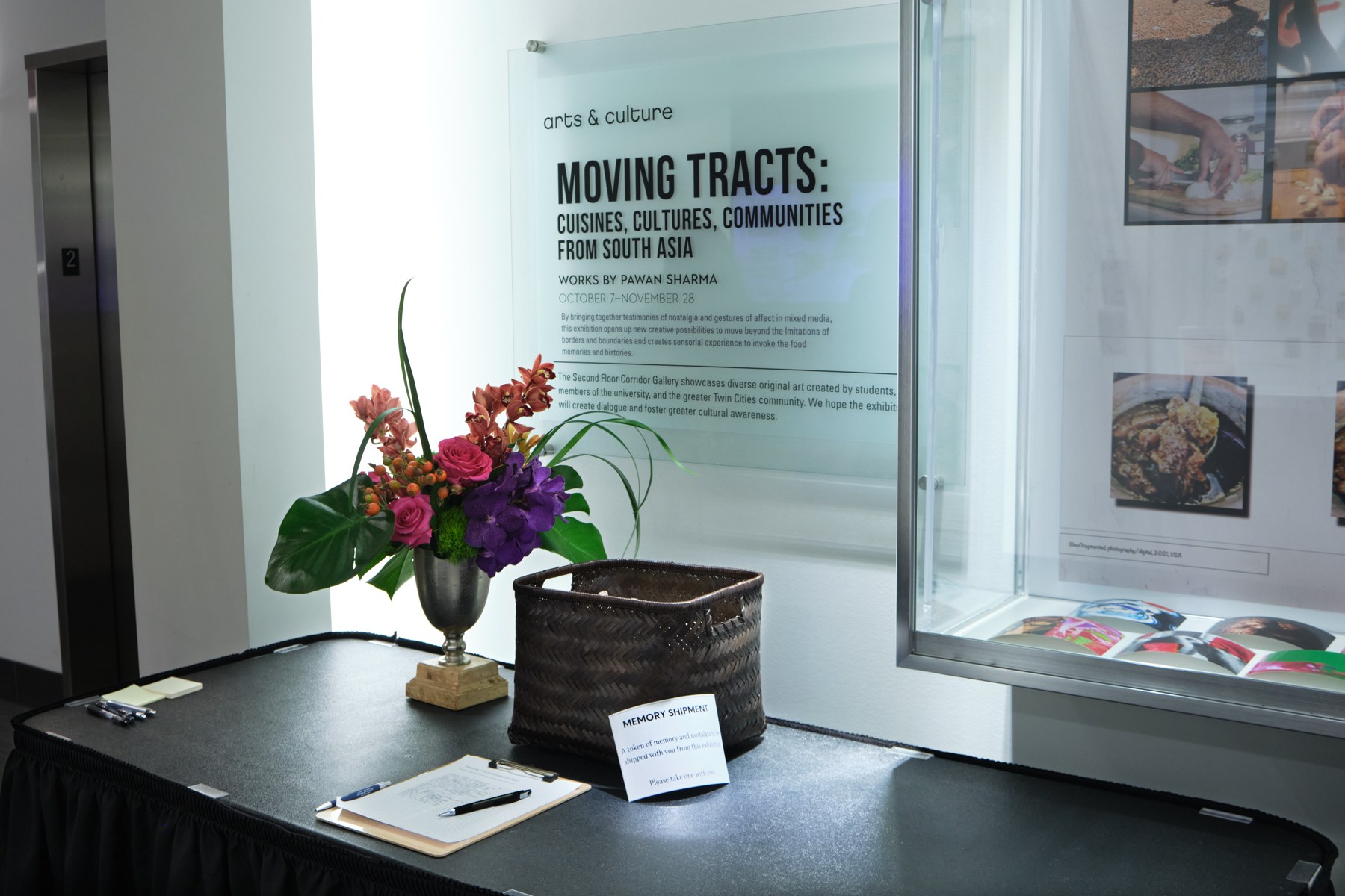 Moving Tracts exhibition with framed photographs, printed stories, and objects